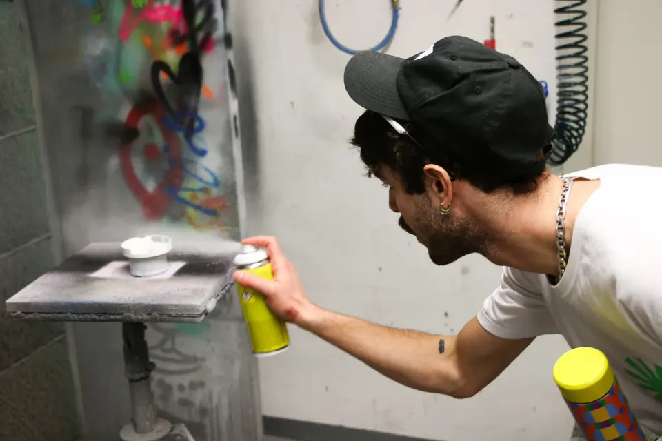 A part being spray-painted in a paint booth